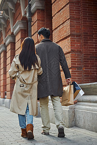 手绘走路的情侣情侣户外挽着手逛街购物背影背景