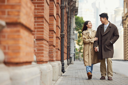 美女走路情侣户外挽着手逛街背景