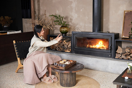 冬天在火炉边取暖的女性背景图片