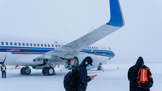 大雪天气机场上的飞机和旅客图片