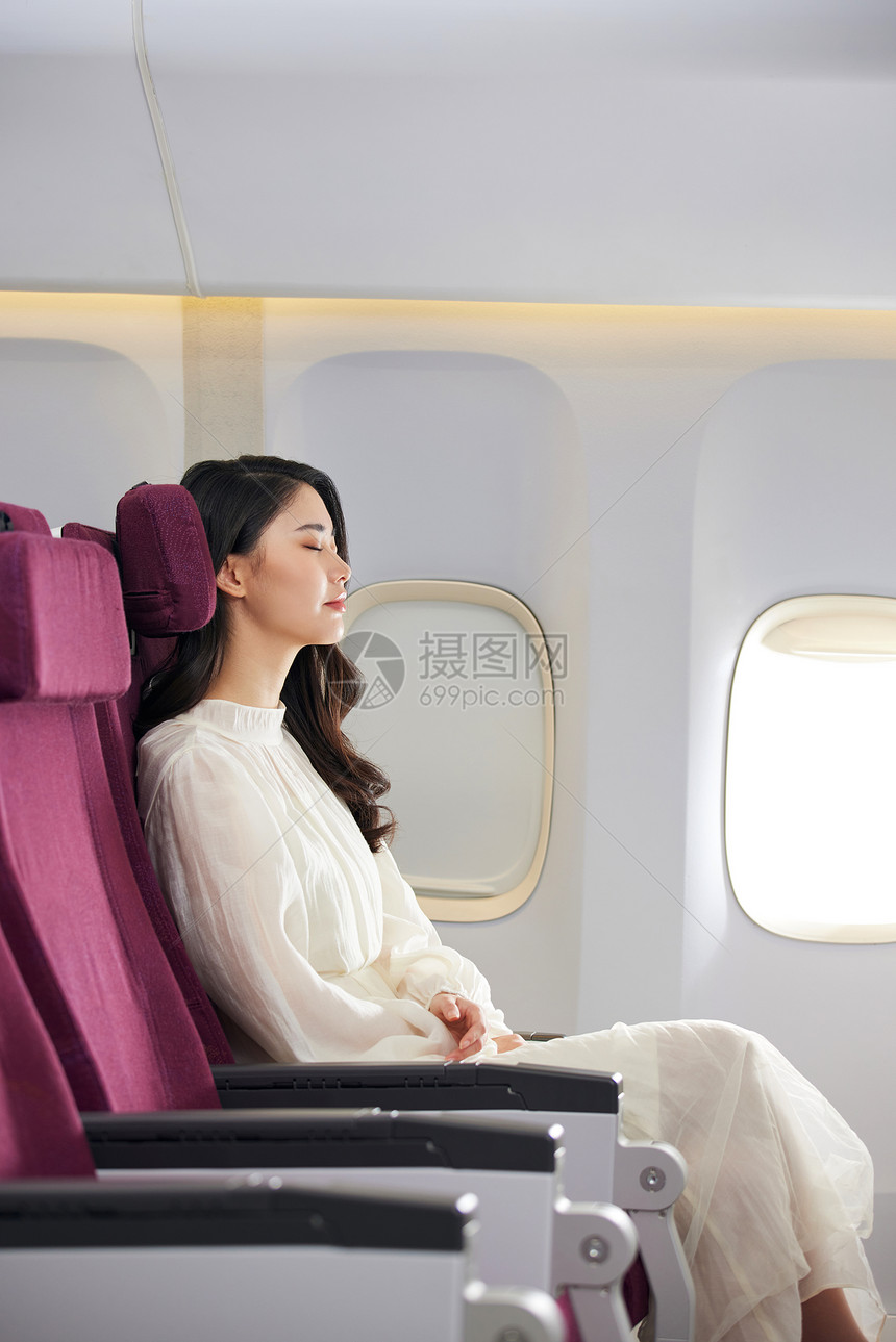 年轻美女乘坐飞机旅行休息睡觉图片