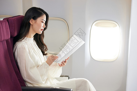飞机上看书年轻美女飞机上翻阅文件背景