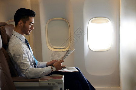 坐在纸飞机上商务男士飞机上看报纸背景