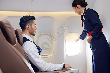 飞机商务舱空姐服务乘客背景图片