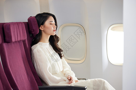 坐着睡觉优雅美女飞机上休息背景