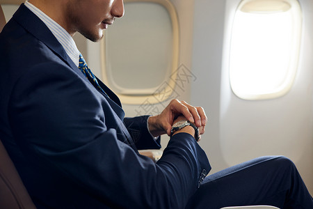 商务男士飞机上看手表图片