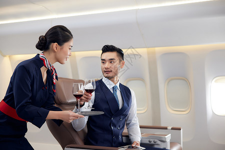 机舱空姐空姐为乘客端上红酒背景