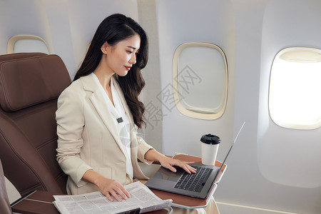 飞女年轻商务女性飞机上办公背景