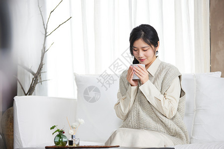 坐着喝茶嫦娥在别墅里度假的女性手捧马克杯背景