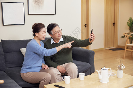 美好美满老人在家使用智能手机打视频电话背景
