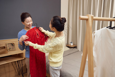 织新衣帮母亲挑选新衣的女儿背景