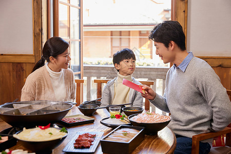 在火锅店吃火锅发红包过新年的家庭图片