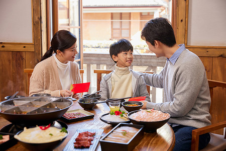 火锅店吃火锅发红包的新年家庭背景图片