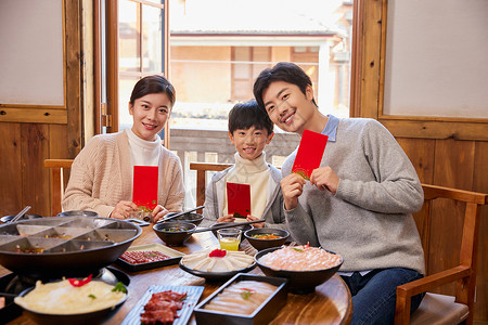 火锅店吃火锅发红包的新年家庭图片