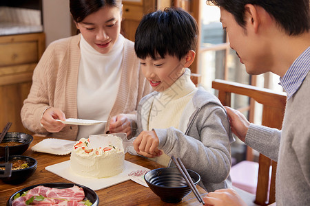 一家三口火锅店切蛋糕开心过生日高清图片