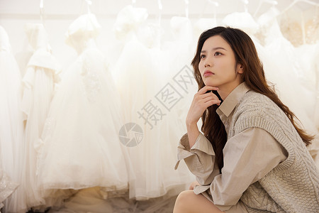 在婚纱店挑选婚纱苦恼的女性高清图片