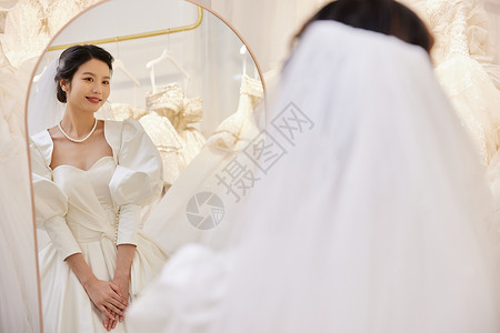 3D试衣镜穿着婚纱站在试衣镜前的女性背景