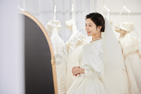 挑选婚纱的新娘照镜子背景图片