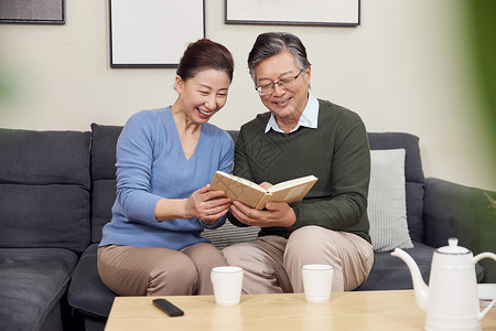 读书的老人爷爷和奶奶在客厅看书背景