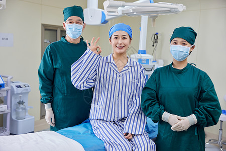 手术成功的患者坐在手术台上和医生合照图片