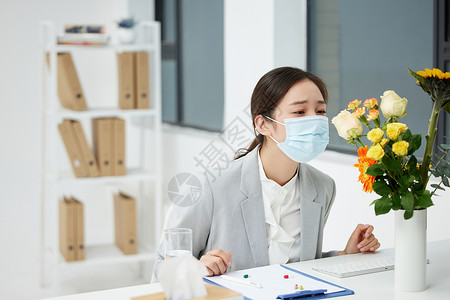 生病戴口罩的青年女性职场商务女性戴口罩预防花粉过敏背景