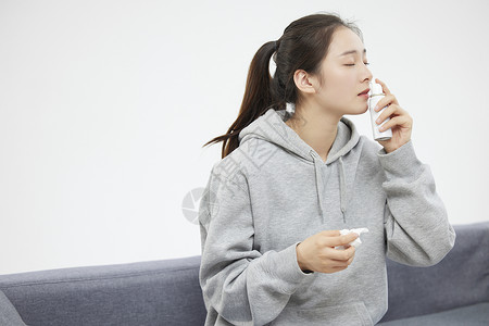 低过敏性居家鼻炎的女性使用鼻炎喷雾背景