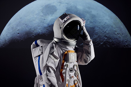 世界航天宇航员站在月球前手扶宇航头盔背景