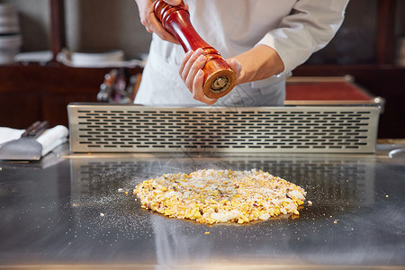 铁板披萨味道厨师为铁板炒饭撒调料背景