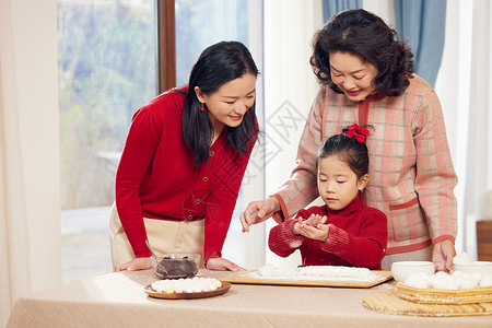 奶奶和妈妈指导小女孩包汤圆背景图片