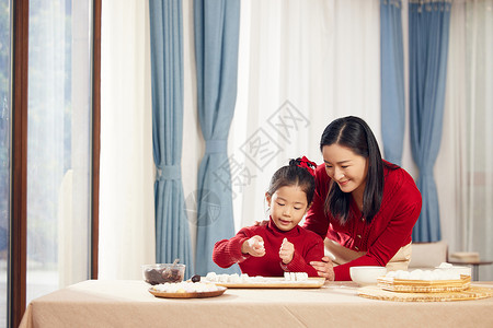 元宵节妈妈陪着女儿包汤圆高清图片