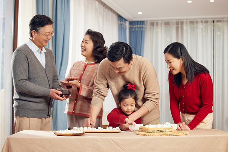 春节里包元宵幸福的一家人背景图片