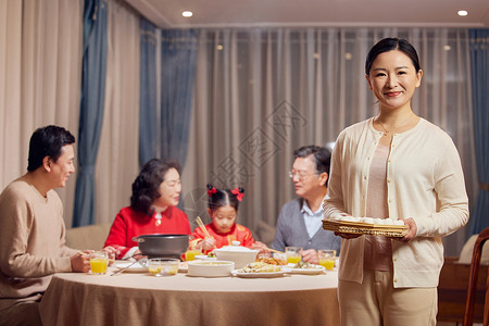 端着汤圆妈妈年轻妈妈元宵节聚餐端着汤圆形象背景