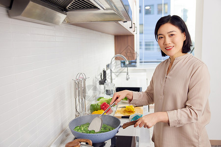 妇女做饭中年短发女性厨房烧菜背景