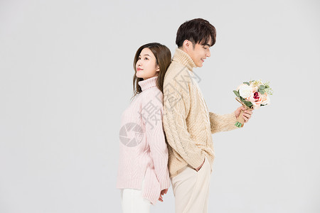 韩系情侣背靠背手拿鲜花图片