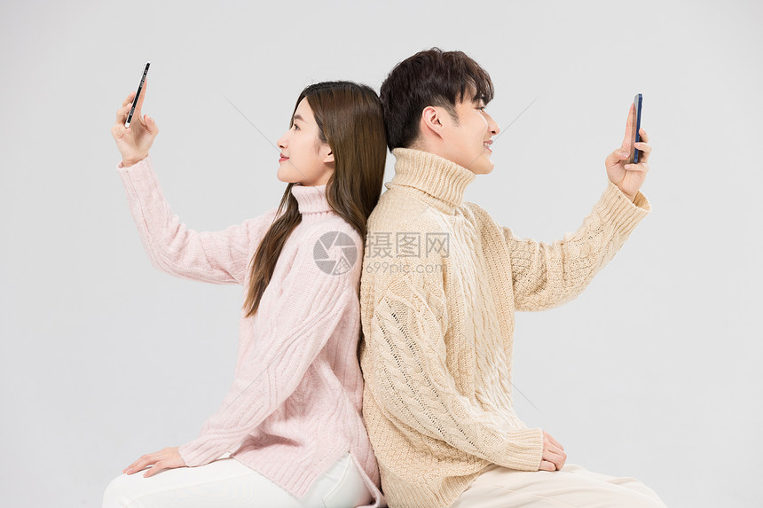 韩系情侣背靠背看手机图片
