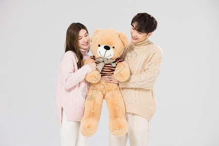 韩系情侣抱着绒毛玩偶熊高清图片