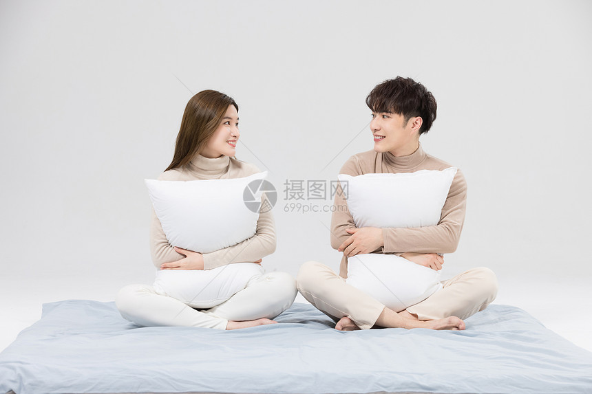 韩系情侣抱着枕头亲密相伴图片