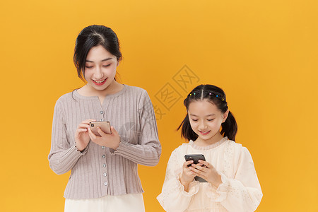 母女二人低头玩手机背景图片