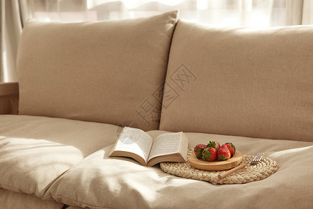 午后阳光日式沙发上的草莓与书籍图片