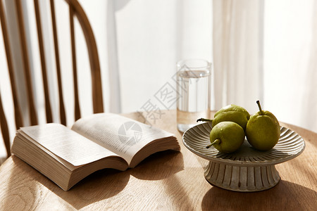 木桌上的书籍与水果图片