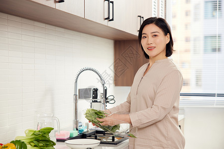 贤惠中年女性厨房洗菜形象背景