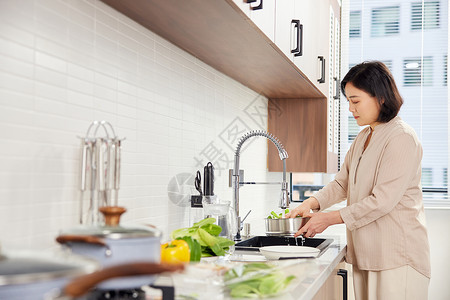 厨房备菜的居家中年女性背景图片