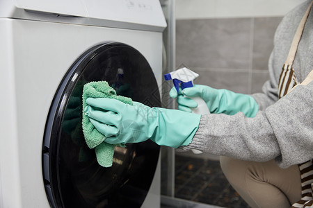 烘干手青年女性给洗衣机消毒特写背景