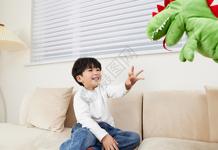 恐龙玩偶小朋友在沙发上跟玩偶玩耍背景