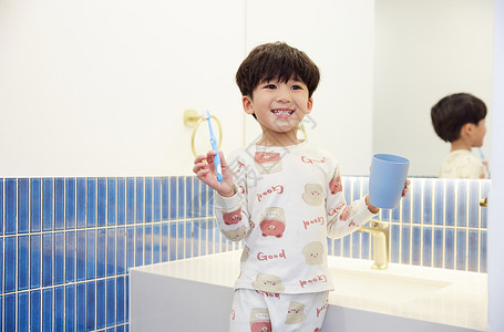 儿童配件穿着睡衣在洗漱台刷牙的小男孩背景