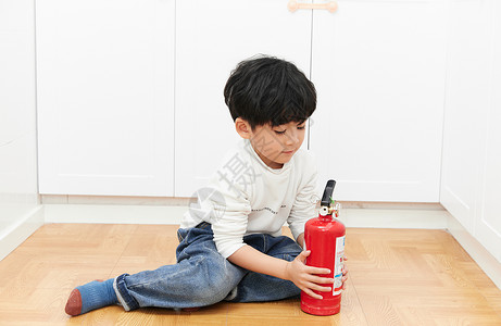 家庭消防素材儿童在厨房里使用灭火器背景