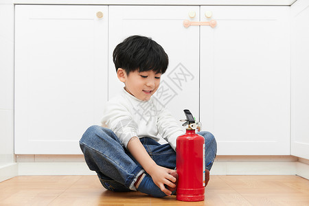 加强消防意识儿童在厨房里操作灭火器背景