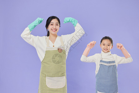 女儿和母亲戴着塑料手套展示力量图片