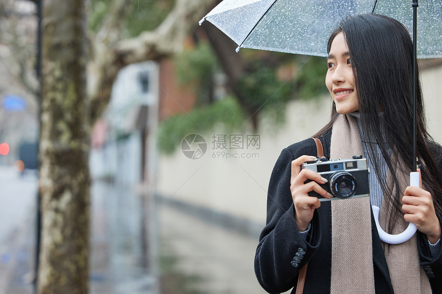 年轻女性雨天拍照图片