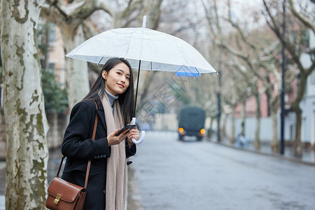 女人撑伞散步雨天路边等车的女性背景